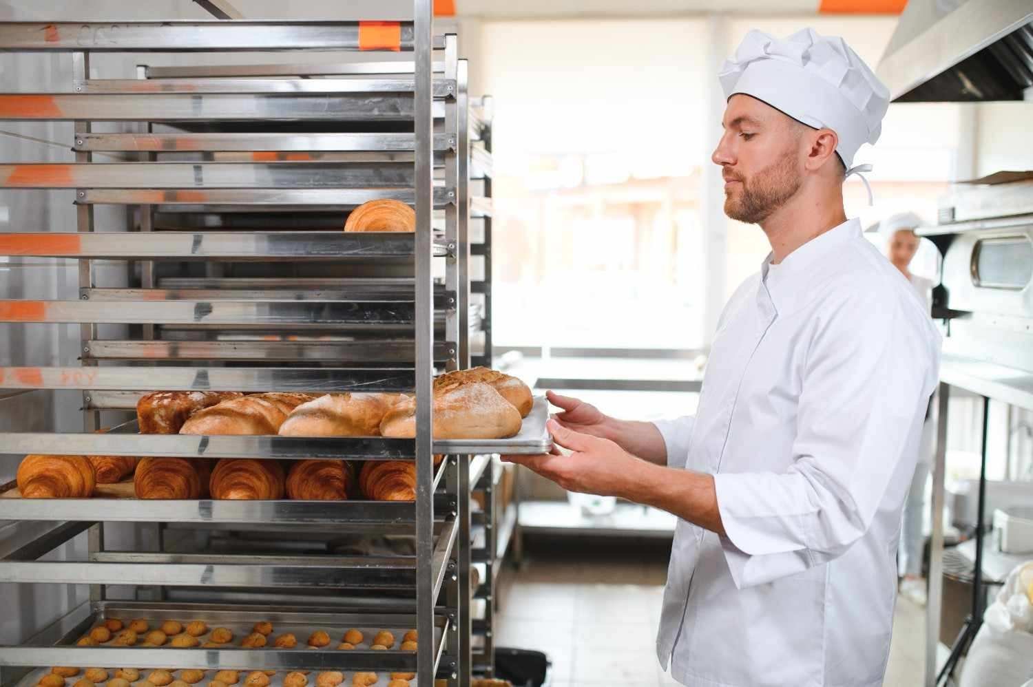 Male Baker Holding Board With Assortment Fresh Bread Shop1