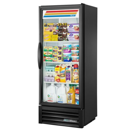 A two-quarter perspective view from the right side of a slim, black True GDM-12-HC commercial refrigerator with a single glass swing door, fully stocked with dairy products and juices.