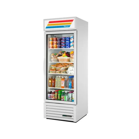 A white True commercial glass door merchandiser refrigerator with a single swing door, showing internal shelves stocked with yogurt, fresh fruit baskets, sandwiches, and bottled drinks.