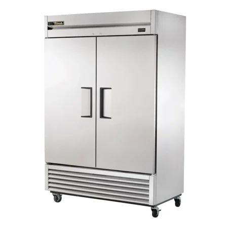 A Large, Two-Door Stainless Steel Commercial Reach-In Freezer By True Manufacturing, Featuring Recessed Handles, A Digital Temperature Display, And Heavy-Duty Casters.