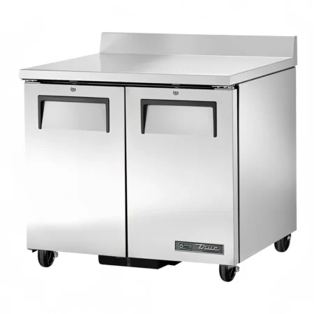A two-door True stainless steel worktop refrigerator with recessed handles, a built-in backsplash, and a heavy-duty mobile base with casters.