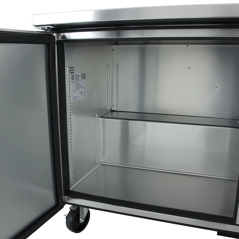 True Twt-60-Hc 60&Quot; Worktop Refrigerator W 2 Sections 115V 6 A Close-Up View Of The Open Left-Hand Interior Section Of A True Twt-60 Worktop Refrigerator, Showing The Clear-Coated Aluminum Liner, Adjustable Shelf Pilasters, And The Manufacturing Data Plate.