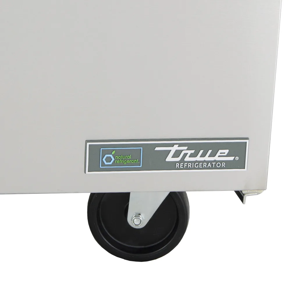 True Twt-60-Hc 60&Quot; Worktop Refrigerator W 2 Sections 115V 7 A Close-Up Of The Bottom Corner Of A True Twt-60 Stainless Steel Refrigerator, Showing The &Quot;True Refrigerator&Quot; Nameplate And A &Quot;Natural Refrigerant&Quot; Badge Above A Heavy-Duty Swivel Caster.