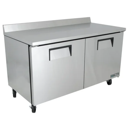 A left-angled view of a 60-inch True stainless steel two-door worktop freezer, showing the full length of the work surface, integrated backsplash, and recessed door handles on heavy-duty casters.