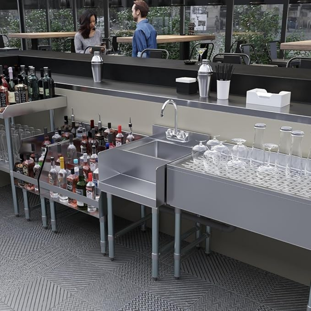 22” X 18” Stainless Steel Blender Station With Dump Sink &Amp; Faucet – Nsf Certified Underbar Beverage Prep Sink For Commercial Bar Restaurant Or Juice Shop 7 A Wide Lifestyle Shot Of A Sleek Underbar Setup In A Modern Bar. The Stainless Steel Blender Station With An Integrated Dump Sink Is Shown Alongside Bottle Storage And Glassware Racks, Illustrating Its Compact Fit And Functionality In A High-Traffic Beverage Prep Area.