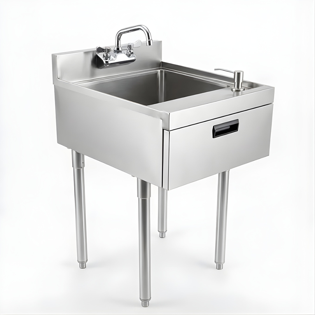 Stainless Steel Underbar Hand Sink With Soap And Towel Dispensers Bowl Faucet And Drain Basket 1 A Low-Angle Perspective Of A Professional Stainless Steel Floor Trough System Installed In A Commercial Kitchen. One Section Of The Metal Grate Is Partially Lifted To Show A Perforated Strainer Basket With A Flat Crossbar Handle Placed Within The Drain To Catch Food Debris. The Background Shows An Industrial Kitchen With Stainless Steel Prep Tables And Gray Tiled Flooring.